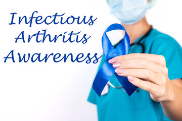 Infectious Artritis awareness concept. A doctor in blue clothes with a blue ribbon in her hand, as a symbol of awareness. - obrazy, fototapety, plakaty