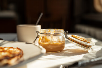 Close-up of a plate of homemade pancakes  with peanut butter, butter and eggs on a table