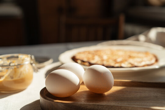 Close-up of a plate of homemade pancakes  with peanut butter and eggs on a table