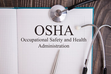 Notebook page with text OSHA Occupational Safety and Health Administration, on a table with a...