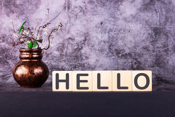 Word HELLO made with wood building blocks on a gray back ground