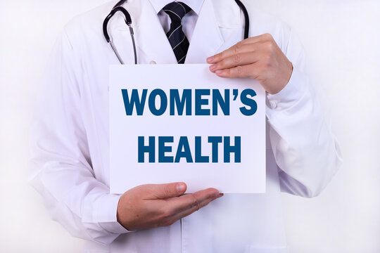 Doctor holding a card with text Women's Health , medical concept.