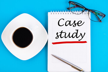 Case study - handwriting on a notebook with pen, glasses and a cup of coffee
