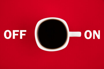 A white cup of coffee is turned on. Concept on a red background.