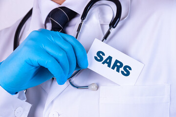 Doctor, man put a card with the text SARS in his pocket. Medical concept.