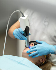 3D scanning of oral cavity. dentist performs 3D scan of oral cavity. Dentist working with intraoral...
