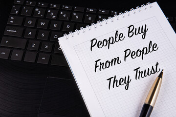 People Buy From People They Trust - written on a notebook with a pen.