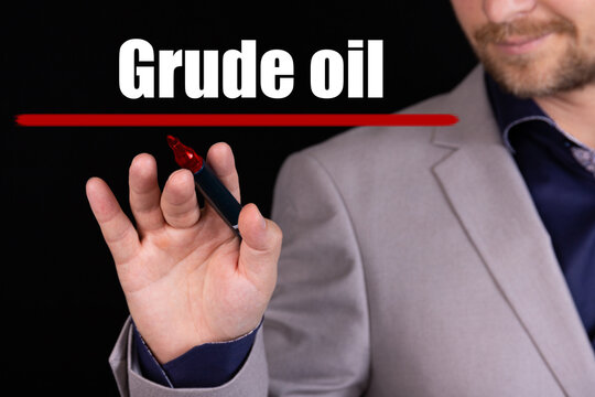 Businessman, man writes marker text on the word GRUDE OIL. Business concept, stteryria.