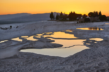 Pamukkale white mineral limestone natural pool at sunset. Turkey