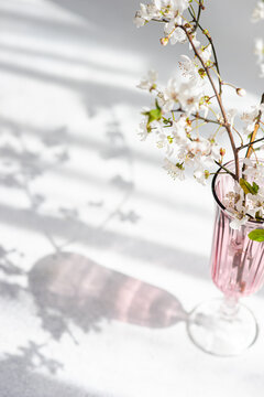 Close-up of a vase filled with a bouquet of white cherry blossom stems in full bloom
