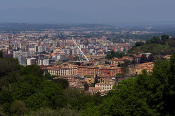 Obraz premium City skyline surrounded by lush greenery and tall buildings in Cosenza, Calabria, Italy