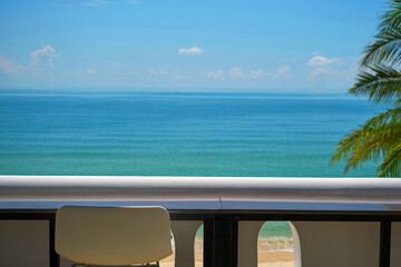 blank seaside working space terrace with white bar stool and balcony and blurred blue sea in background