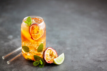 Fruit ice tea. Refreshing summer drink with syrup, passion fruit, lime, mint and ice. Glass with cold and healthy beverage