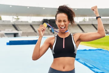 Tuinposter Black woman, athlete and victory with medal stadium as champion for competition or game in Brazil. Portrait, winner and wink with prize or award for success, achievement and happy for sport career © peopleimages.com
