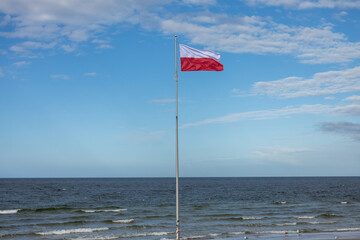 Polskie barwy narodowe, Polska flaga  na tle nieba nad morzem. Bałtyk Kołobrzeg Zachodniopomorskie 