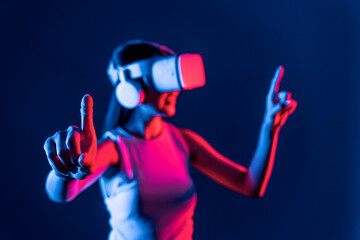 Smart female stand with surrounded by cyberpunk neon light wear VR headset connecting metaverse,...