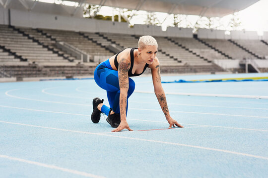 Woman, runner and start for sports, exercise and warm up in stadium or field for fitness. Female athlete, training and track in outdoor for wellness, performance and strong in cardio, body and mind
