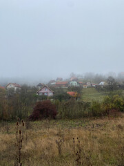 Fototapeta premium rural houses in a Serbian village in the morning in the fog on n the mountains