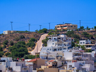 Buildings and a steep slope on hillside (Elounda, Crete, Greece)