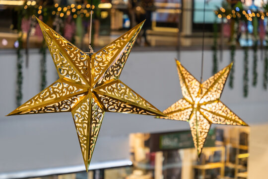 Close-up view of the glowing stars decoration hanging in the shopping mall during celebration Merry Christmas.