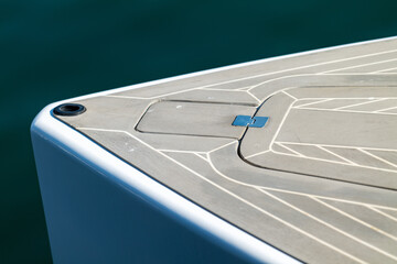 The bow of a beautiful powerboat with nice clean lines showing the deck and hatch.