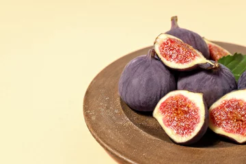  Fresh ripe figs in a wooden bowl on a light background © Atlas