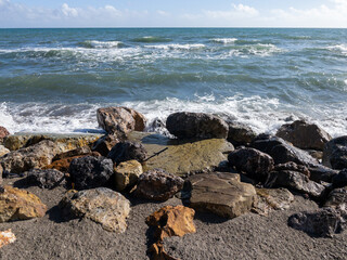 Veduta marina, scogli e onde che si frangono sulla spiaggia in primavera