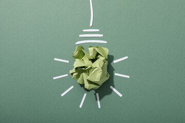 A light bulb made of crumpled paper, the concept of an eco house