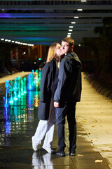 A beautiful young couple. A girl in white clothes and a man in black clothes at night in the park. - 788046563