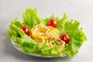 Italian cuisine dish - pasta with cherry tomatoes and lettuce. Healthy food