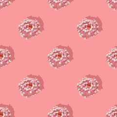 Repeating pattern of pink donuts with marshmallows on a pink background