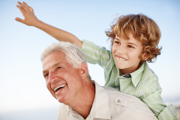 Happy, blue sky and child playing with grandfather for bonding, relationship and relax together outdoors. Family, nature and grandpa with young boy on summer holiday, vacation and weekend at park