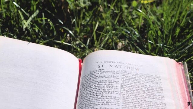 Bible Book on Field of Grass on a Sunny Day, Gospel of St Matthew.