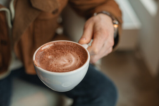 Close-up of a man sitting in a cafe drinking a cup of coffee