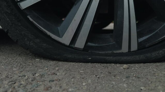 Cityscape Struggle: Parked Car with Flat Tyre