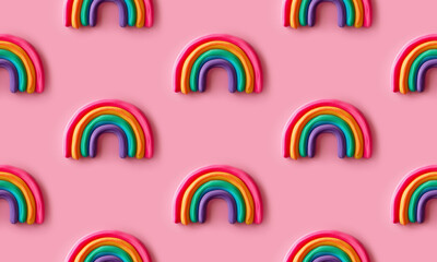 Seamless pattern with rows of multicolored rainbows made with soft foam standing against pink background. Creative and trendy concept. 3d style print