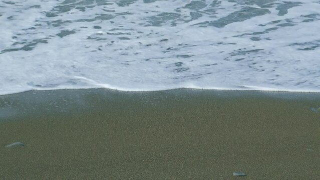 The Sea Water Foams From The Waves. Holiday Recreation Concept. Sea Waves Washes Sand Beach. Slow motion.