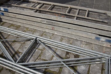 fragments of scaffolding stacked on paving stones