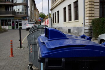 trash can with a blue lid on a city street,,