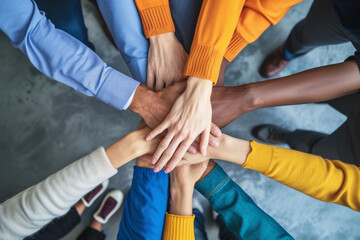 Diverse team of professionals joining hands in unity and teamwork