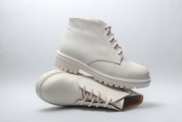 Trendy Women's white leather winter boots on white background.