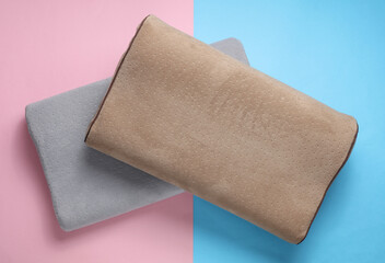 Orthopedic two pillows on a blue-pink pastel background. Healthy and comfortable sleep