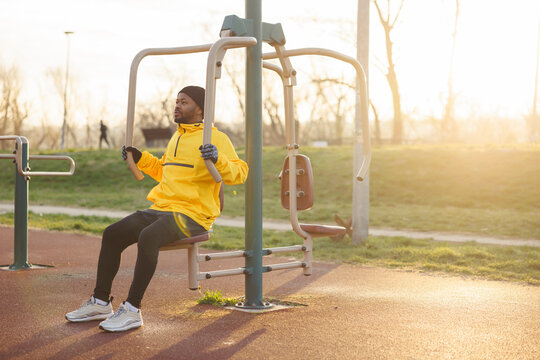 Man exercising on pec deck machine while working out in an outdoor gym