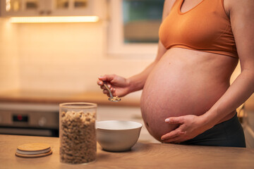 A close-up shot of an unrecognizable pregnant woman having oatmeal for breakfast