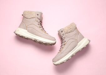 Women's winter boots on a pink background. Top view