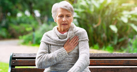 Senior woman, heart attack and pain in park, pneumonia and cardiac risk or hypertension in nature. Female person, heartburn and stress on lungs or bench, stroke and danger of healthcare or disease - obrazy, fototapety, plakaty