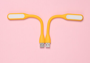 Flexible yellow USB lamps on pink background. Top view