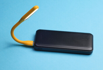 Power bank with Flexible yellow USB lamp on blue background.