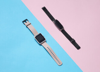 Modern smart watch and bracelet on a blue-pink background