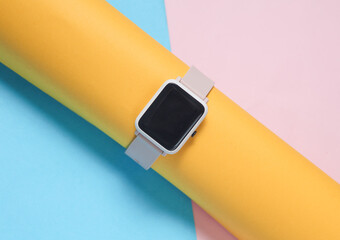 Smart watch on a blue-pink background. Modern gadget. Minimalism. Creatrive layout